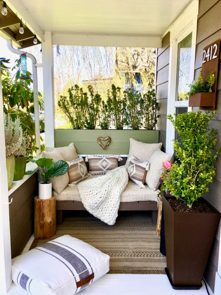 Small apartment balcony decorated with container plants and seating